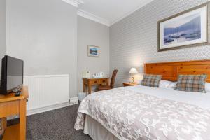 um quarto com uma cama e uma televisão de ecrã plano em Ormsgill Inn em Barrow in Furness