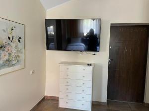 a room with a dresser and a television on the wall at Apartamenty Jaskinia Solna in Ruda Śląska
