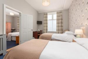 a hotel room with two beds and a window at Ormsgill Inn in Barrow in Furness