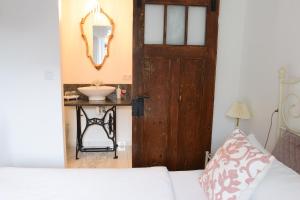 um quarto com uma cama e uma casa de banho com um lavatório em Guest House Wiejska Sielanka em Brody