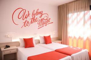 a bedroom with two beds and a sign that readsloveley to the universe at Lloret Vibe Affiliated by FERGUS in Lloret de Mar