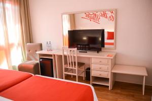 a room with a desk with a tv and a mirror at Lloret Vibe Affiliated by FERGUS in Lloret de Mar