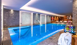 una piscina en una habitación de hotel con una gran piscina azul en Sassdei My Active Suite Hotel en Andalo