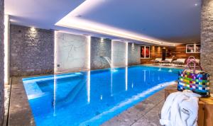 a swimming pool in a hotel room with a large blue pool at Sassdei My Active Suite Hotel in Andalo