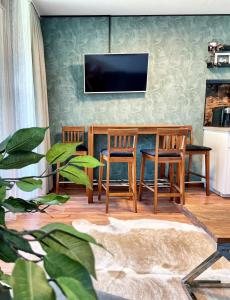 salon ze stołem, krzesłami i telewizorem w obiekcie Viktor Apartment w mieście Titisee-Neustadt