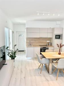 - une cuisine et une salle à manger avec une table et des chaises dans l'établissement CASHMERE Premium Apartment, à Siófok