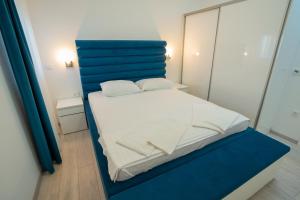 a bed with a blue headboard in a room at The Princess in Novalja