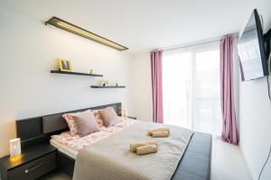 A bed or beds in a room at Andante Panoráma Apartman