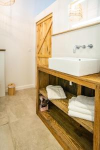 a bathroom with a sink and a shelf with towels at Welcôm Apparts-chic et intimiste-100m du Port in La Teste-de-Buch +25 photos