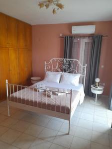 a bedroom with a bed with a white bed frame and a window at Nestor Sea Studio in Preveza