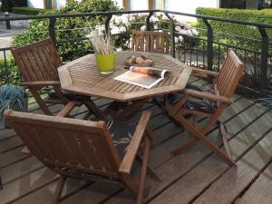 een houten tafel en stoelen op een terras bij Kaiservillen Heringsdorf - Ferienwohnung mit 1 Schlafzimmer und Terrasse D101 in Heringsdorf