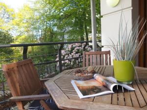 een houten tafel met een boek erop op een balkon bij Kaiservillen Heringsdorf - Ferienwohnung mit 1 Schlafzimmer und Terrasse D101 in Heringsdorf