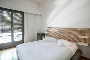 ein weißes Schlafzimmer mit einem großen Bett und einem Fenster in der Unterkunft app.national museum in Athen