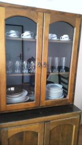 a wooden cabinet with plates and dishes in it at Holiday house Cikola in Kaočine