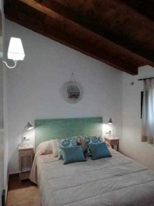 a bedroom with a large bed with blue pillows at Rubielos de Mora Ollerías in Rubielos de Mora
