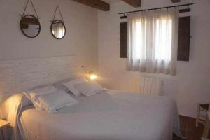 a bedroom with a large white bed with a window at Rubielos de Mora Ollerías in Rubielos de Mora