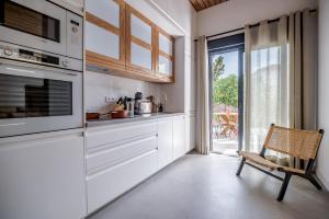 a kitchen with white cabinets and a sliding glass door at Luxury Villa Alhambra close to Sea and Centre in Benalmádena