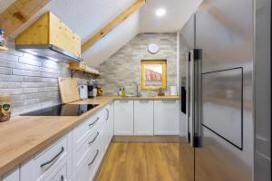 eine Küche mit weißen Schränken und einem Kühlschrank aus Edelstahl in der Unterkunft Holiday Home Mali Medo in Gospić