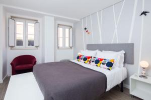 a bedroom with a bed and a red chair at Designer Flats in Lapa by LovelyStay in Lisbon