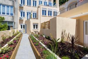 a walkway in front of a building with flowers at Designer Flats in Lapa by LovelyStay in Lisbon