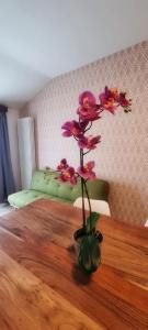 un jarrón de flores sentado en una mesa de madera en Casa Barcelli Sport & Family Apartments, en Nago-Torbole