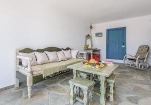a living room with a couch and a table with a bowl of fruit at Koufiakas boathouse in Pollonia