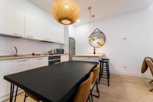 cocina y comedor con mesa negra y sillas en GETARIA SUITE Apartment en San Sebastián