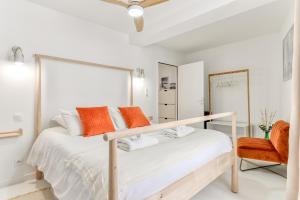 a white bedroom with a bed and a chair at Les Gîtes de Laure - L'Or Blanc, Appartement avec Vue sur le Chateau, Climatisation, Netflix, à 160 m de la Cité Médiévale in Carcassonne
