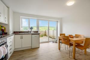 a kitchen with a table and a dining room with a window at 3 Tyn Y Mynydd in Betws-y-coed