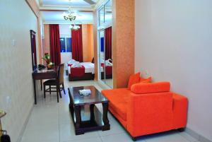 a living room with a red couch and a table at Al Qidra Hotel & Suites Aqaba in Aqaba