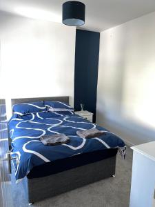 a bedroom with a bed with a blue and white comforter at 4-6 Guests in centre location with stunning views in Llanberis