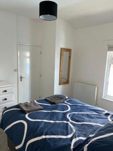 a bedroom with a bed with a blue and white blanket at 4-6 Guests in centre location with stunning views in Llanberis