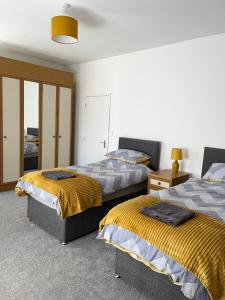 a bedroom with two beds and a mirror at 4-6 Guests in centre location with stunning views in Llanberis