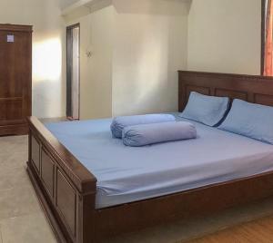 Una cama grande con almohadas azules encima. en Homestay Panrita Bone, 