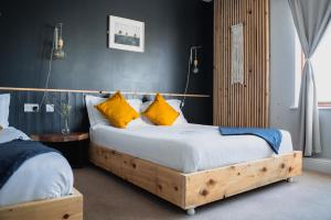 1 Schlafzimmer mit 2 Betten und gelben Kissen in der Unterkunft BigStyle Atlantic Lodge 