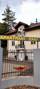 een hek voor een huis met een bord erop bij Apartmani Zagi in Rakovica