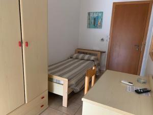 a small room with a small bed and a table at Hotel Tokio in Lido di Jesolo