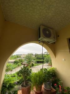 a room with an arched window with a fan and plants at Hostel DIA in Tsqaltubo +4 photos