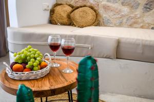 a table with two glasses of wine and a basket of fruit at Aggeliki's Diamond in Agia Anna Naxos