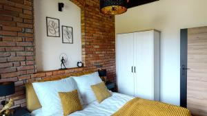 a bedroom with a brick wall and a bed at AltHaus in Sasino