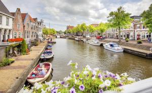 a group of boats on a river in a city at Boutiquehotel Dokkum in Dokkum