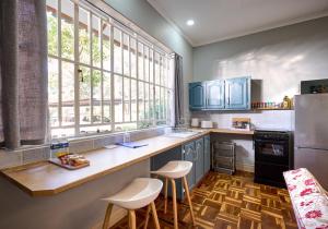 a kitchen with blue cabinets and a counter with stools at The BeeKeeper's Inn in Louis Trichardt
