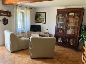 a living room with two chairs and a television at Bellavista Cascianella in Piazza al Serchio