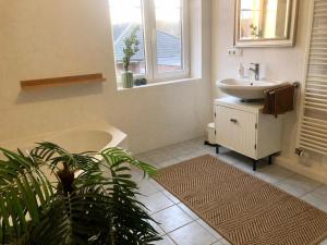 a bathroom with a sink and a tub and a toilet at Wohlfühl Villa Garding in Garding