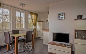 ein Wohnzimmer mit Tisch und Fernseher in der Unterkunft Haus Meeresblick - Ferienwohnung Suedost A 4.05 (Ref. 128720) in Baabe