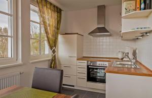 eine Küche mit Spüle und Herd oberen Backofen in der Unterkunft Haus Meeresblick - Ferienwohnung Suedost A 4.05 (Ref. 128720) in Baabe + 7 Fotos