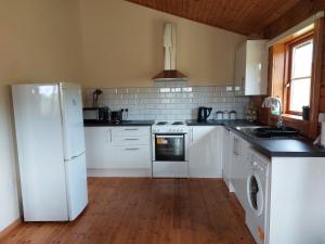 a kitchen with white appliances and a wooden floor at Farm lodge in Shepton Mallet