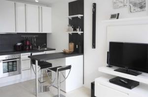 a kitchen with white cabinets and a black counter top at Haus Meeresblick - Ferienwohnung Windlicht A 2.08 (Ref. 128696) in Baabe