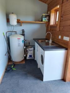 a laundry room with a sink and a washing machine at Farm lodge in Shepton Mallet