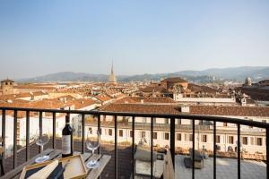 Una finestra sui tetti di Torino في تورينو: إطلالة على المدينة من شرفة مع كؤوس للنبيذ